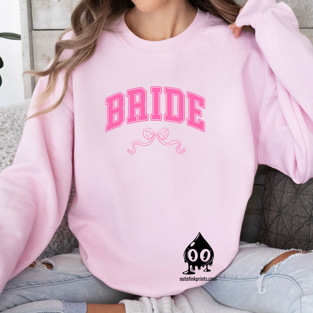 Front view of a pink sweatshirt with the word 'Bride' and a pink bow on it.