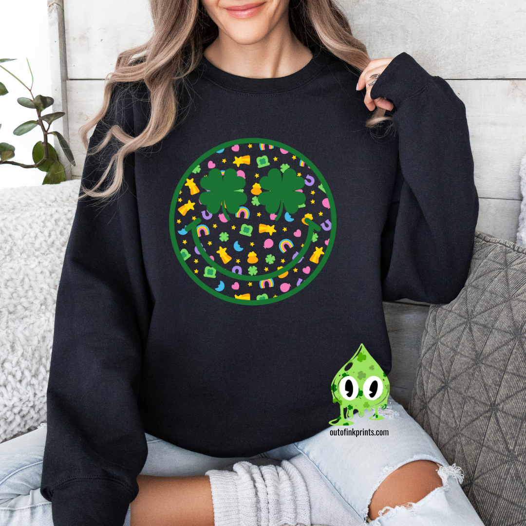 A person wearing a black sweatshirt with a smiley face design made of clovers and multicolored elements on the front.