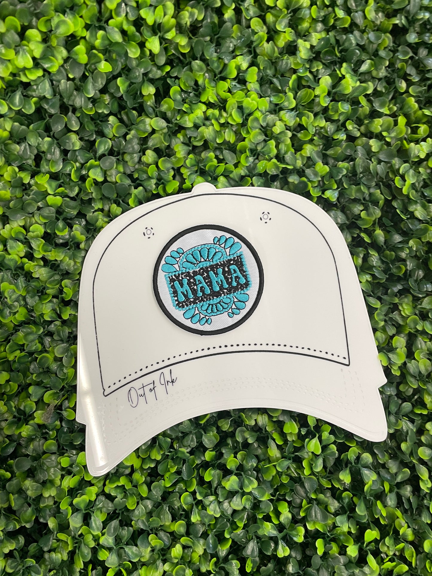 Circular patch with 'MAMA' text placed on a white trucker hat graphic