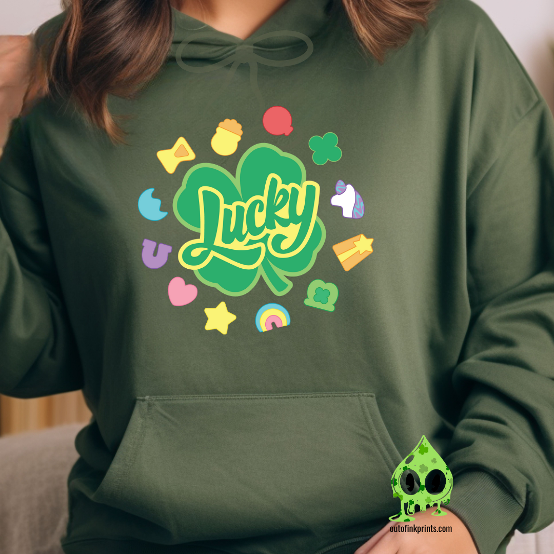 A green hoodie with a 'Lucky Marshmallows' graphic in green, featuring clovers and other St. Patrick's Day themed elements.