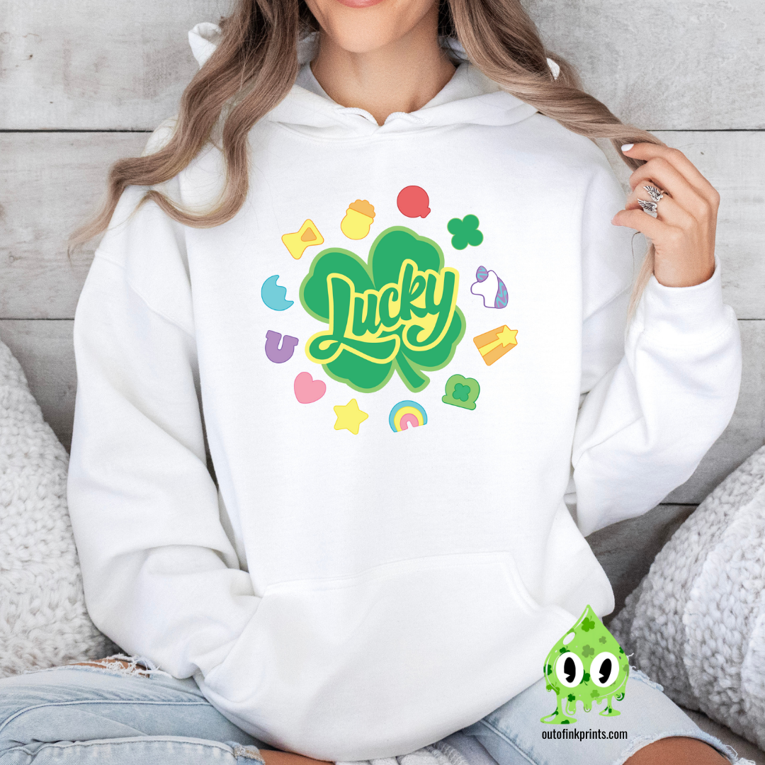A white hoodie with a 'Lucky Marshmallows' graphic in green, featuring clovers and other St. Patrick's Day themed elements.