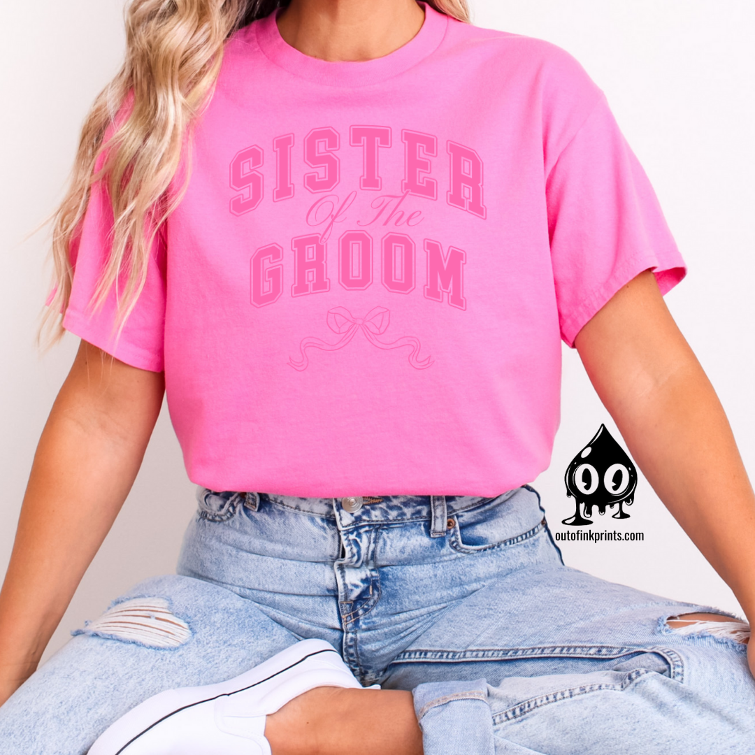 A woman wearing a pink shirt with 'Sister of the Groom' text and a pink bow design on it.