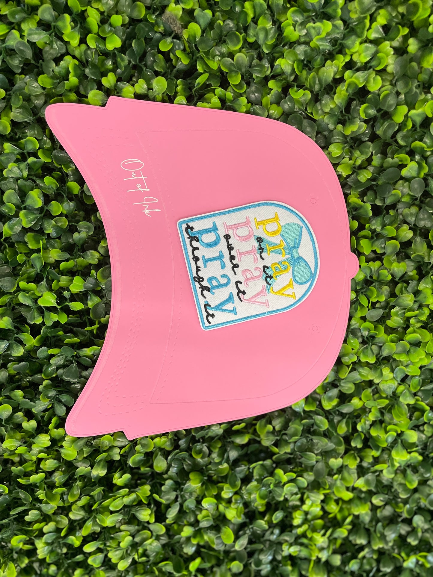 Embroidered patch with 'pray on it, pray over it, pray through it' text in various colors placed on a pink trucker hat graphic