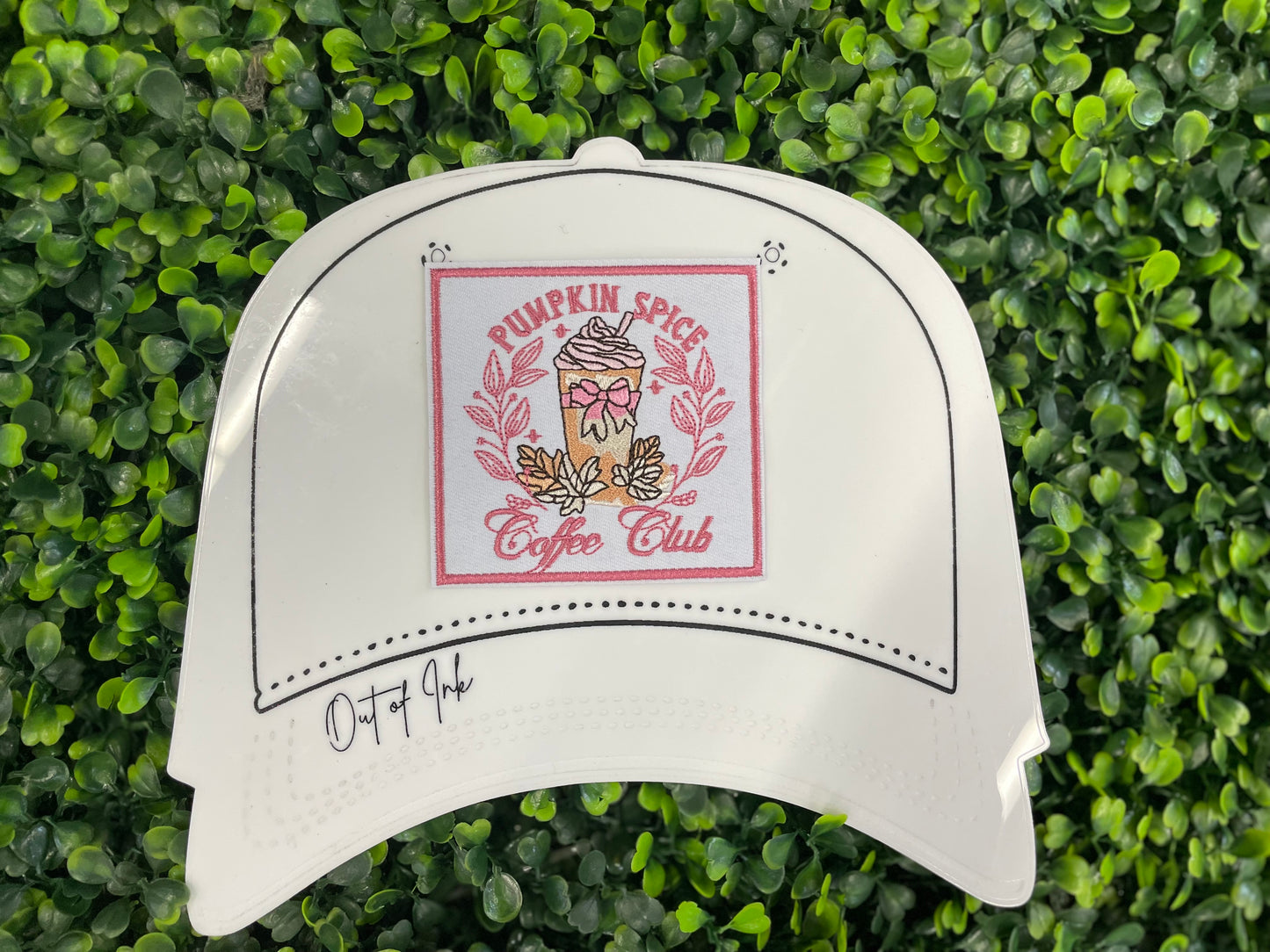Sticker with pumpkin spice latte design and the text "pumpkin spice coffee club" placed on a white trucker hat graphic