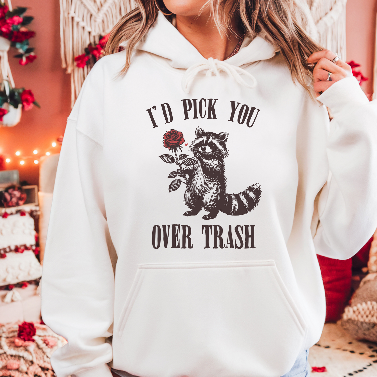 A sweatshirt with a raccoon on the front and the text "I'd pick you over trash" around the raccoon