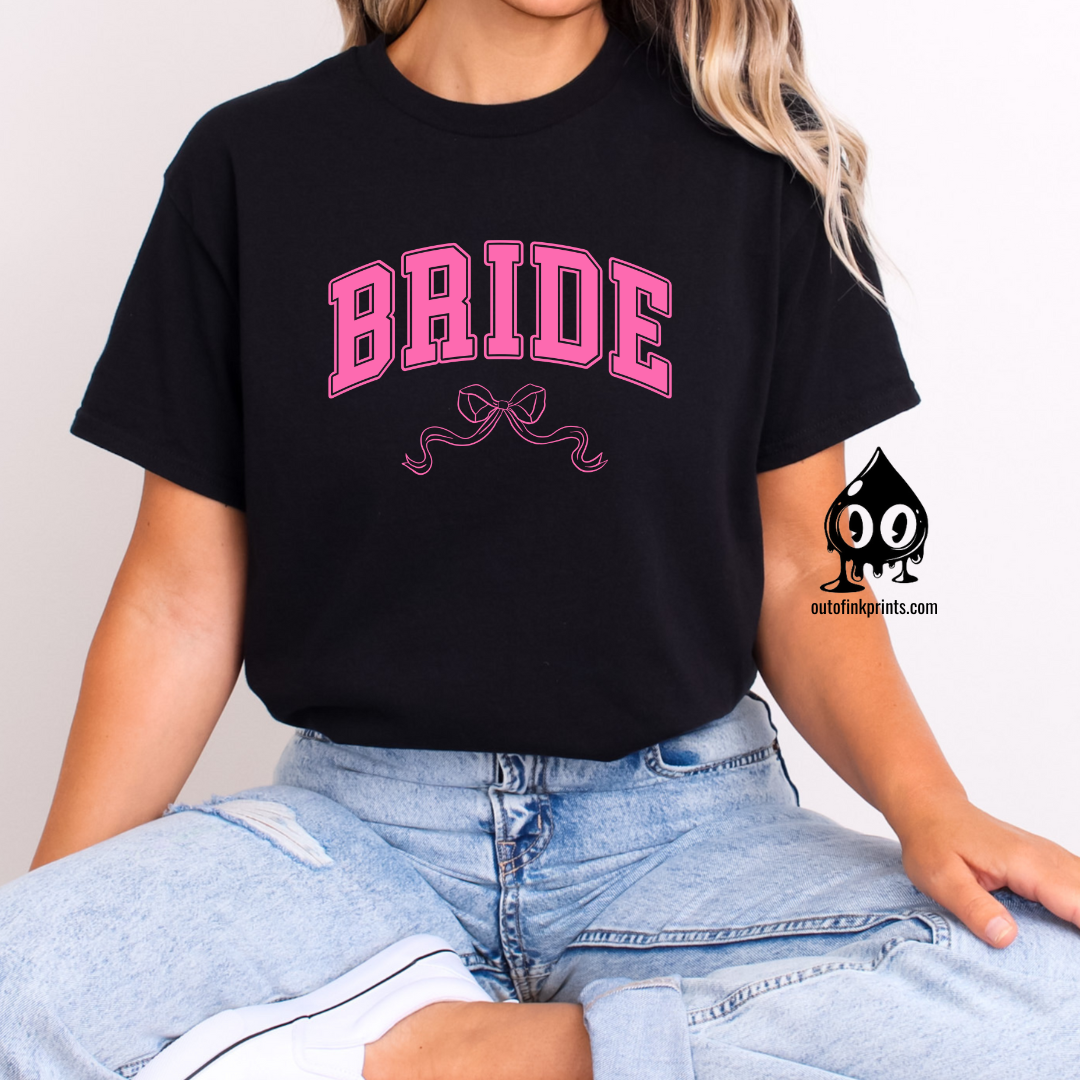 Front view of a black t-shirt with the word 'Bride' and a pink bow graphic on it.