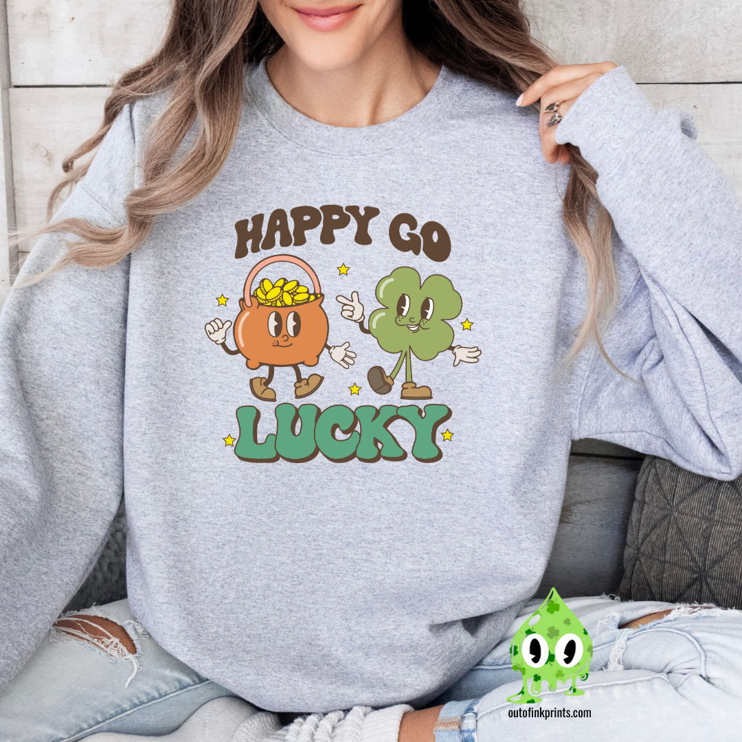 A woman wearing a grey sweatshirt with the text 'HAPPY GO LUCKY' and a graphic of a smiling face and a four leaf clover.