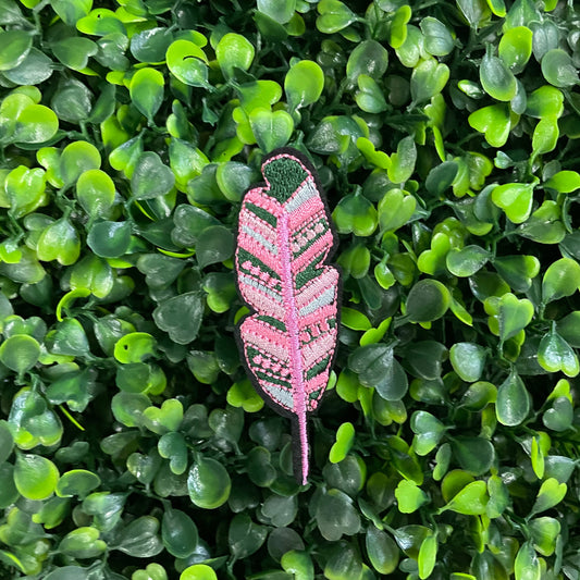 Pink feather-shaped patch on a bed of green leaves