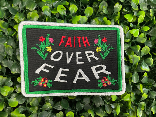Embroidered patch with 'Faith Over Fear' text on a green leaf background