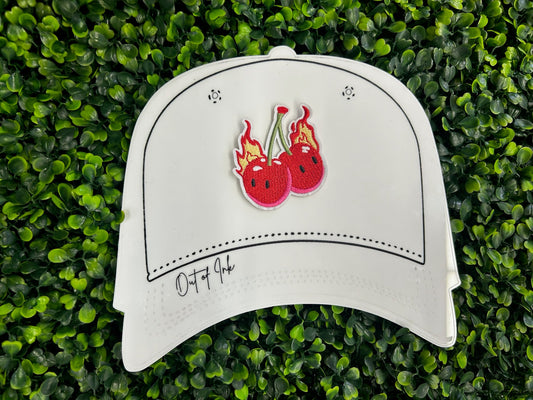 White cat-shaped object with red cherry design on a green grass background