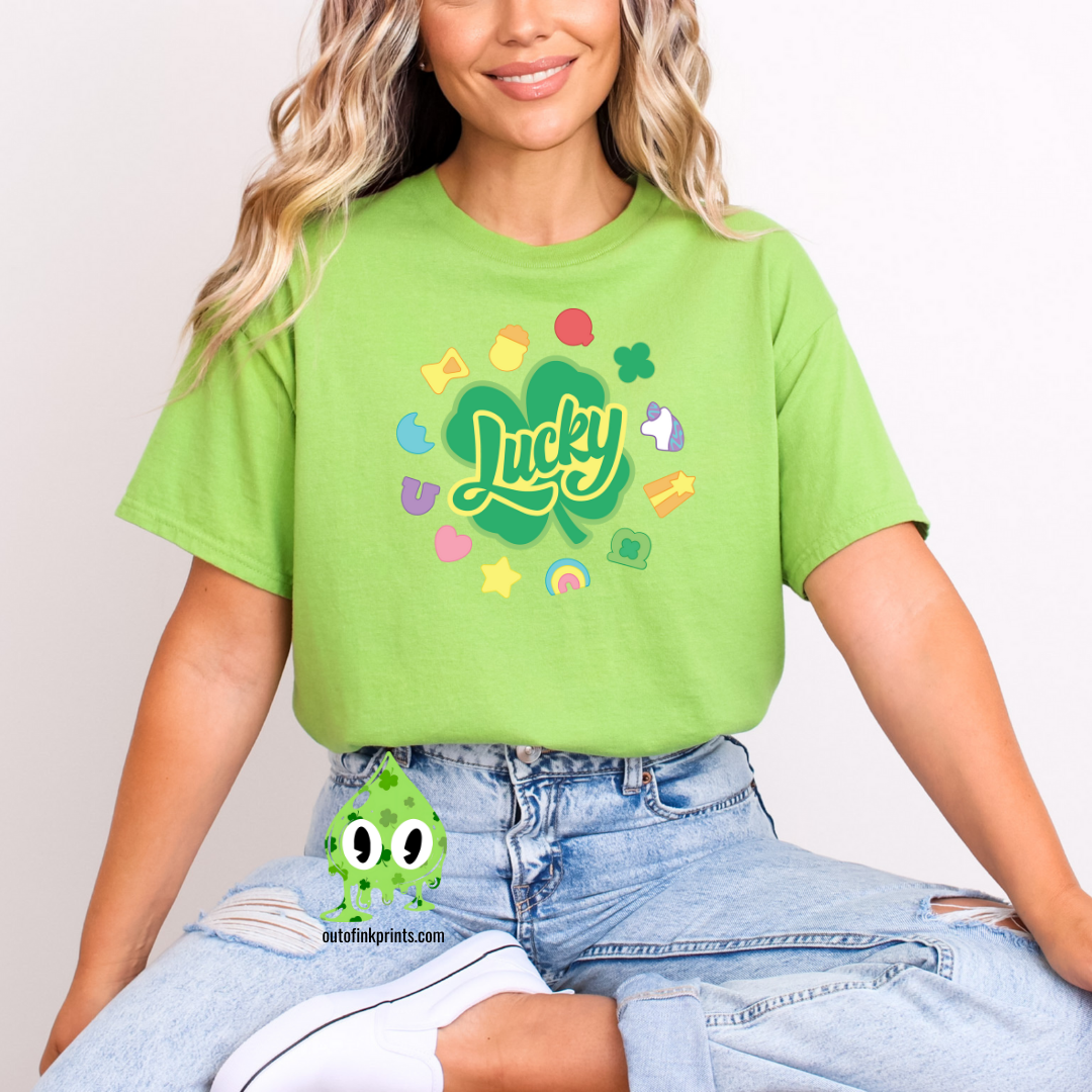 Front view of a green t-shirt with the text 'Lucky Marshmallows' and various colorful graphic elements.