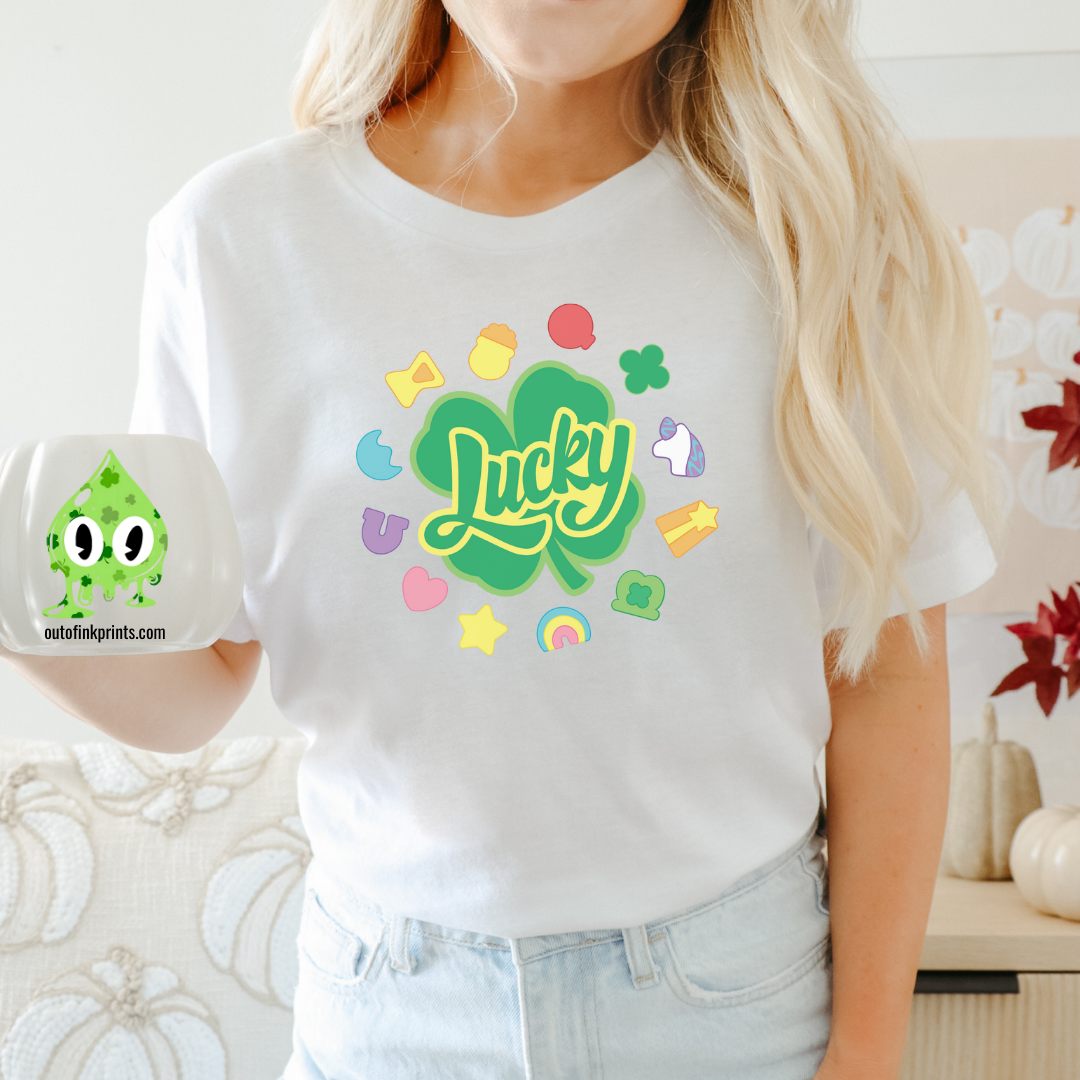 Front view of a white t-shirt with the text 'Lucky Marshmallows' and various colorful graphic elements.