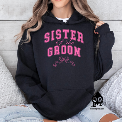 A woman wearing a black hoodie with 'Sister of the Groom' text and a pink bow design.