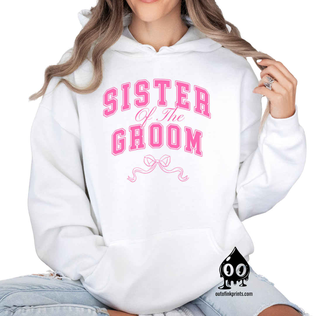 A woman wearing a white hoodie with 'Sister of the Groom' text and a pink bow design.