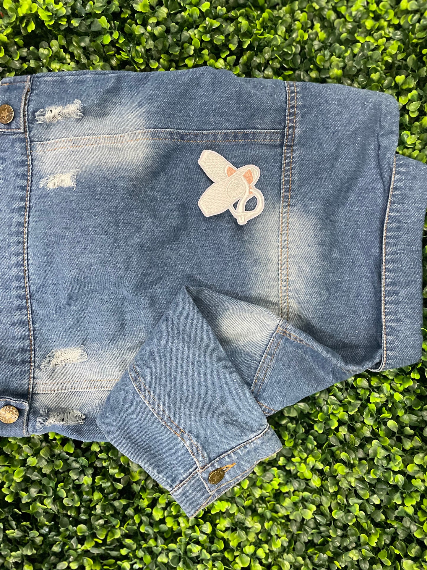 Embroidered patch of a pair of ballet slippers placed onto a child's denim jean jacket