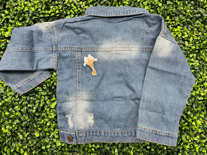 A patch in the shape of a vintage key with a gold bow, embroidery work, set on a jean jacket