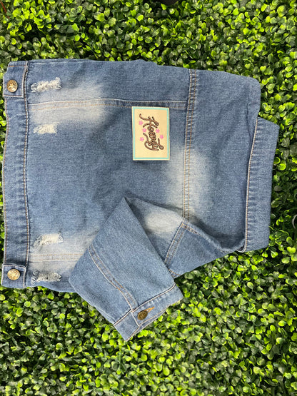 Embroidered patch with brown "Howdy" text on a tan background with a light blue border, placed on a children's denim jean jacket