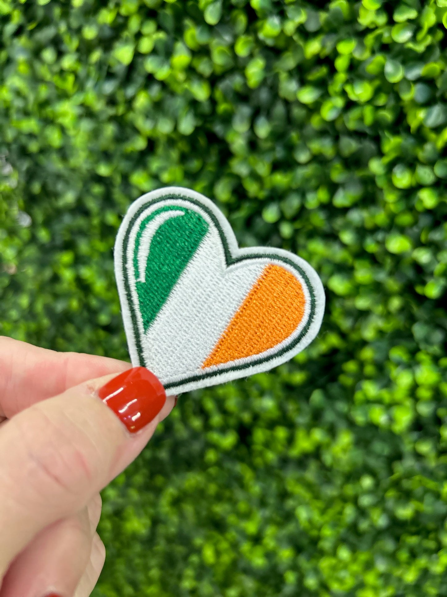 Heart shaped embroidered patch with Ireland flag colors green white and orange.