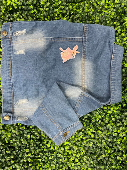 Embroidered patch of a pink bunny white a pink bow placed on a child's denim jean jacket