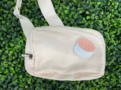 An embroidered patch in the shape of a bundle of roses with pink petals and green leaves, placed on a white bag