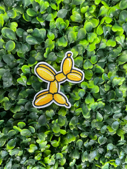 Yellow balloon dog-shaped patch on green foliage
