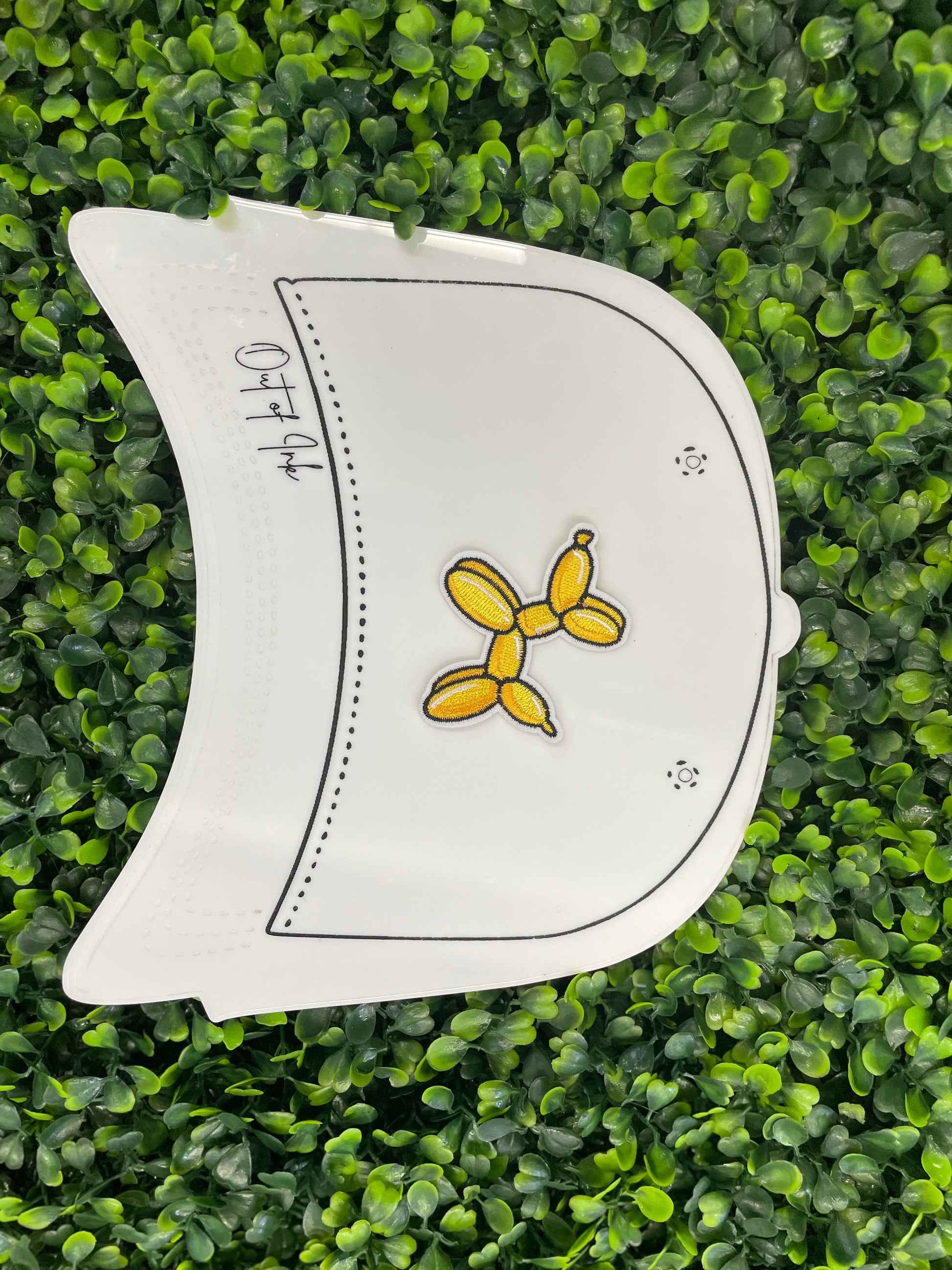 Yellow balloon dog-shaped patch placed on a white trucker hat graphic